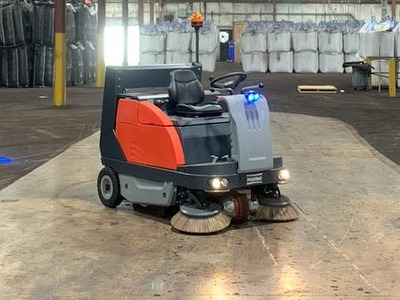 PowerBoss rider sweeper in an industrial warehouse